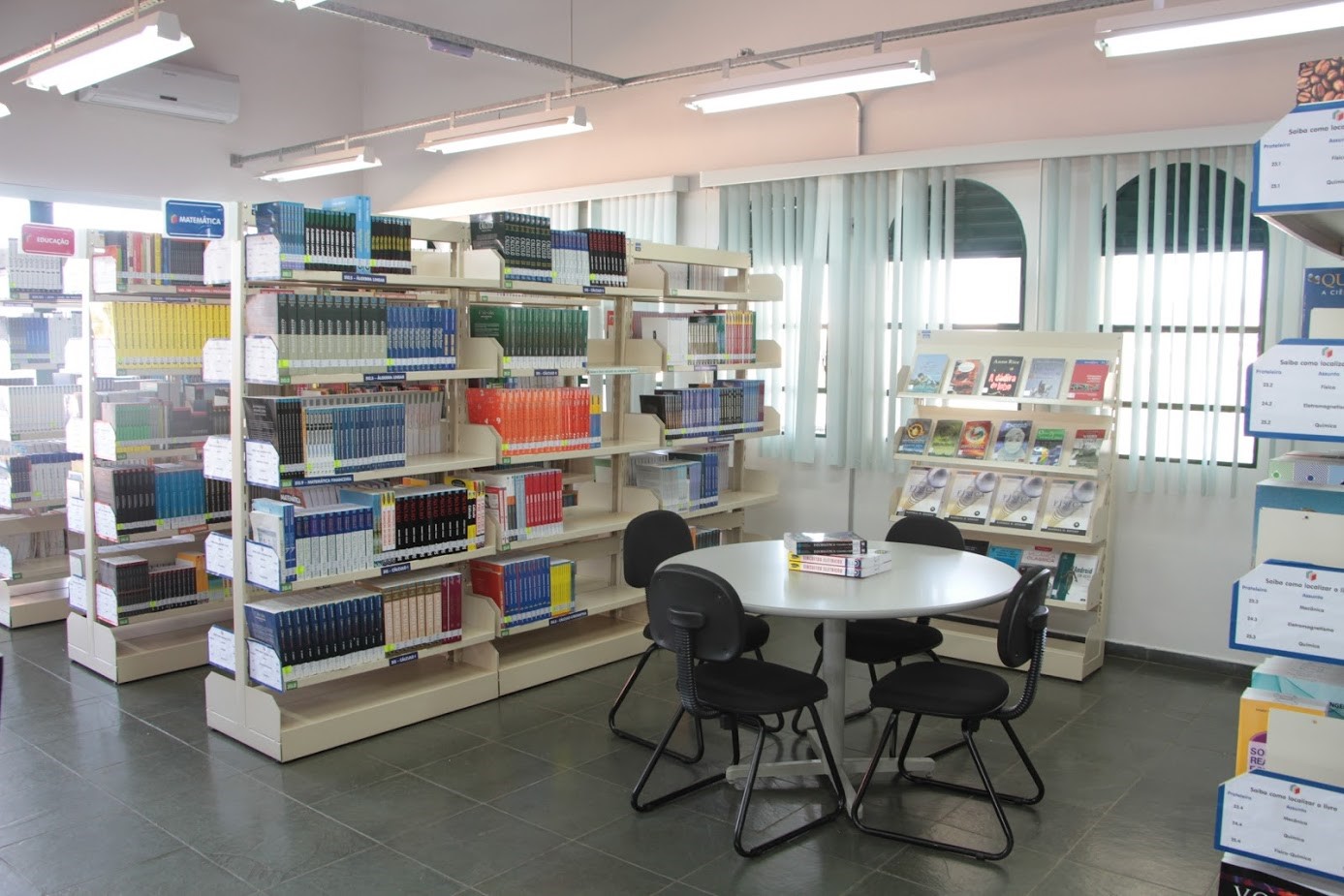 Foto da vista interna da biblioteca; estantes de livros